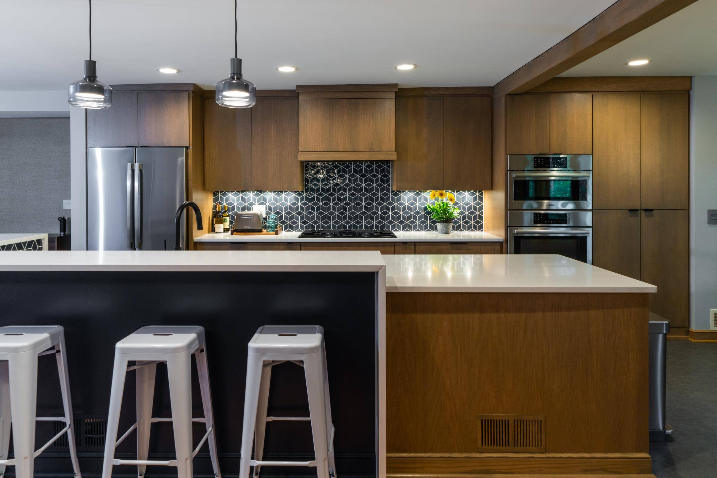 Remodeled kitchen with patterned backsplash and storage in island by Hanson Remodeling