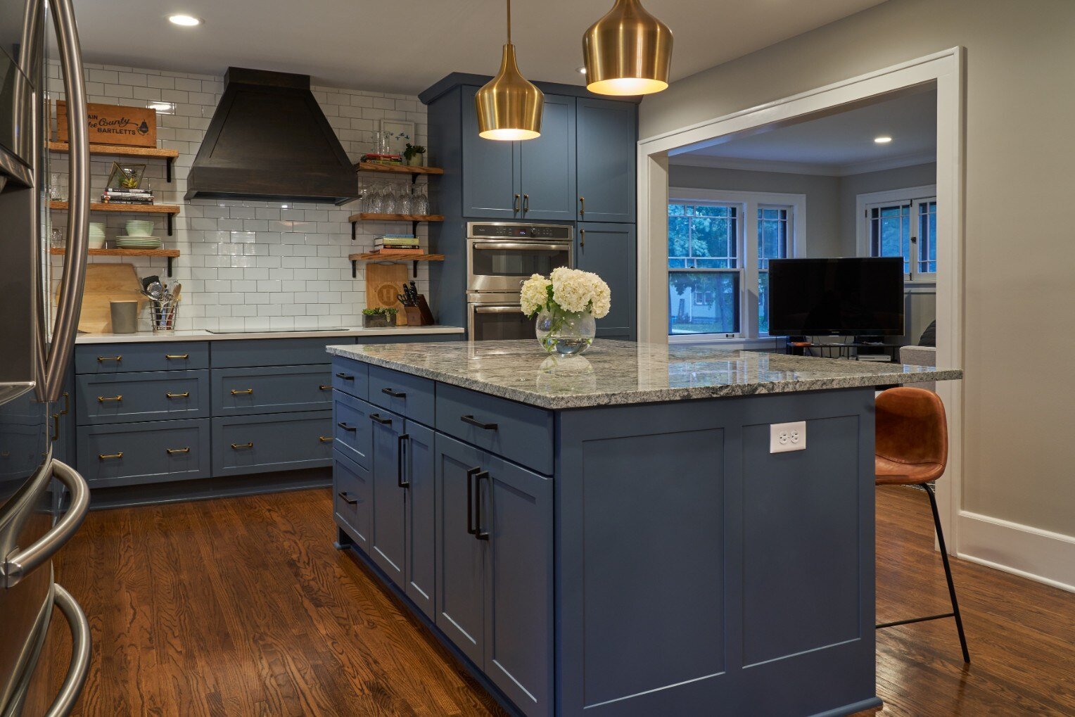 Remodeled kitchen with blue cabinetry and white tile backsplash by Hanson Remodeling